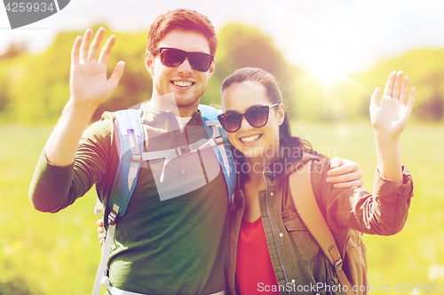 Image of happy couple with backpacks hiking outdoors