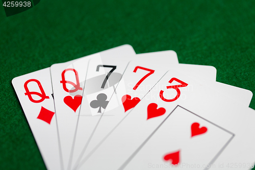 Image of poker hand of playing cards on green casino cloth