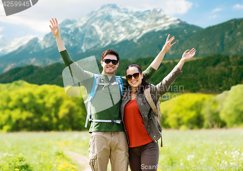 Image of happy couple with backpacks hiking outdoors