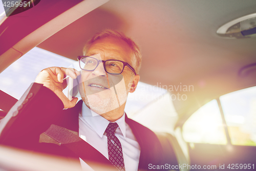 Image of senior businessman calling on smartphone in car