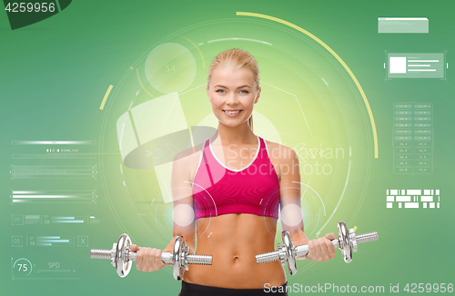 Image of happy sporty woman with dumbbells flexing biceps