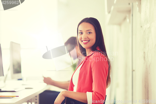 Image of happy african woman with computer at office
