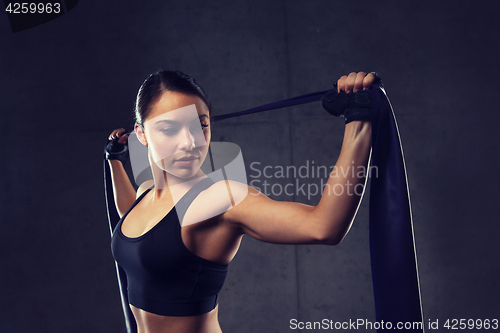 Image of woman with expander exercising in gym