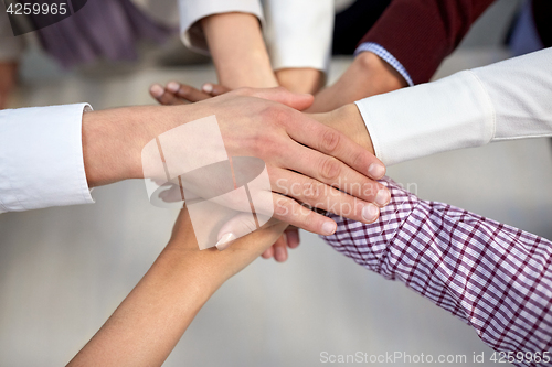 Image of business team with hands on top at office