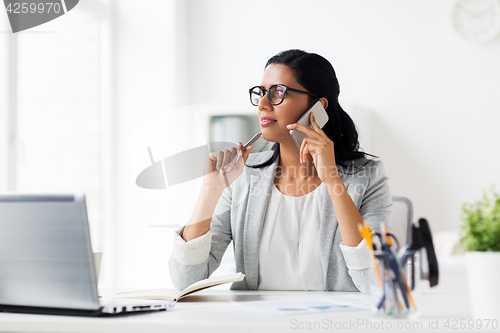 Image of businesswoman calling on smartphone at office