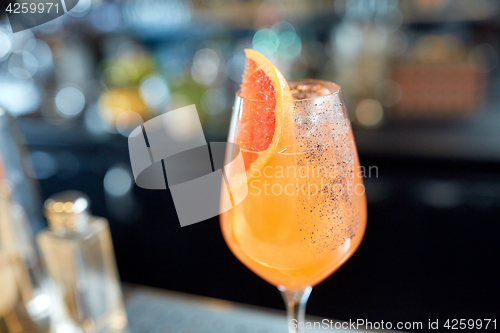 Image of glass of grapefruit cocktail at bar