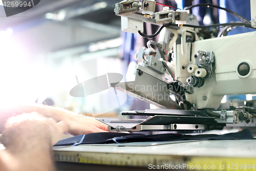 Image of Overlock. Sewing machine. The woman sewing on the machine.