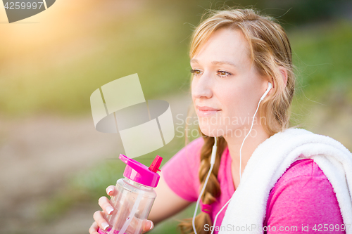 Image of Young Fit Adult Woman Outdoors With Towel and Water Bottle in Wo