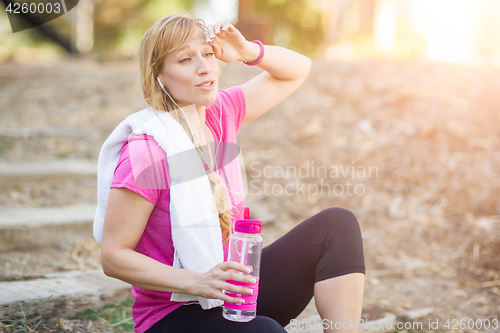 Image of Young Fit Adult Woman Outdoors With Towel and Water Bottle in Wo