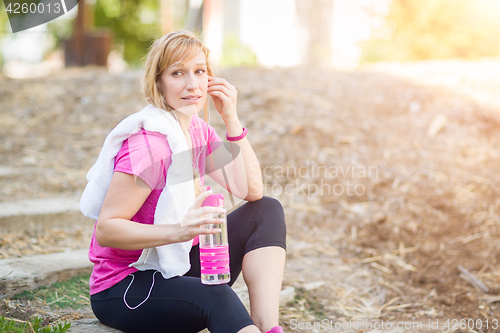 Image of Young Fit Adult Woman Outdoors With Towel and Water Bottle in Wo