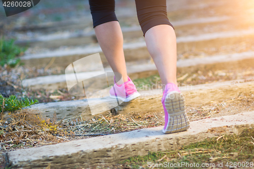 Image of Young Fit Adult Woman Outdoors Walking or Running Up Wooden Step