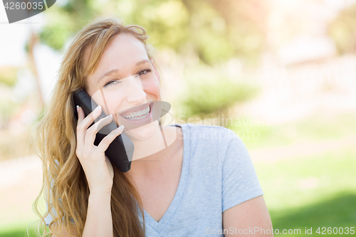Image of Young Adult Woman Outdoors Talking on Her Smart Phone.