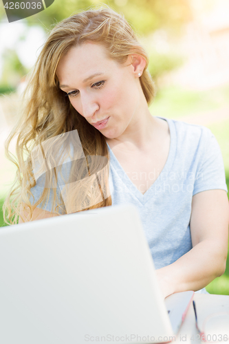Image of Young Adult Woman Live Video Chatting Outdoors Using Her Laptop.
