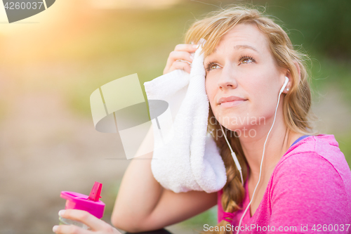 Image of Young Fit Adult Woman Outdoors With Towel and Water Bottle in Wo