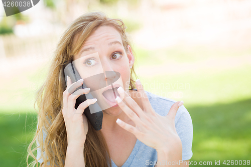 Image of Stunned Young Woman Outdoors Talking on Her Smart Phone.