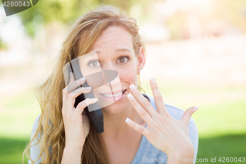 Image of Stunned Young Woman Outdoors Talking on Her Smart Phone.