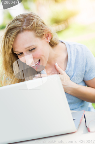 Image of Young Adult Woman Live Video Chatting Outdoors Using Her Laptop.