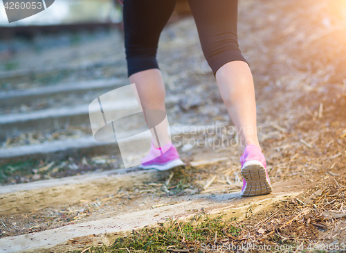 Image of Young Fit Adult Woman Outdoors Walking or Running Up Wooden Step