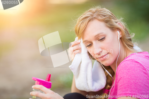 Image of Young Fit Adult Woman Outdoors With Towel and Water Bottle in Wo