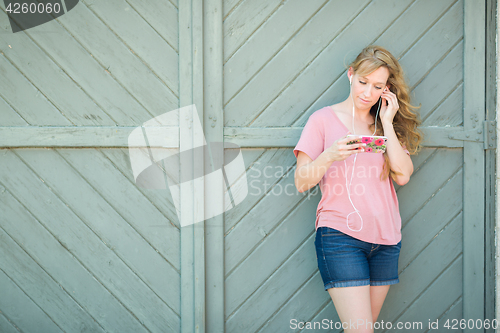 Image of Outdoor Portrait of Young Adult Brown Eyed Woman Listening To Mu