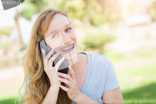 Image of Young Adult Woman Outdoors Talking on Her Smart Phone.