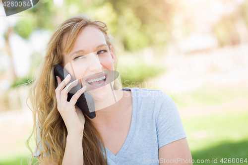 Image of Young Adult Woman Outdoors Talking on Her Smart Phone.