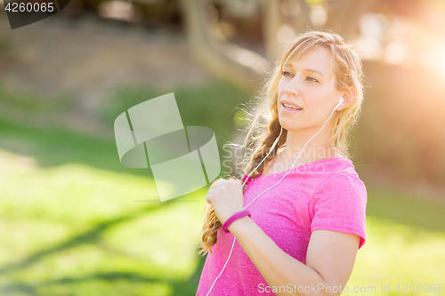 Image of Young Fit Adult Woman Outdoors During Workout Listening To Music