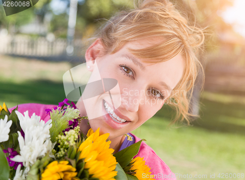 Image of Outdoor Portrait of an Excited Young Adult Brown Eyed Woman Hold