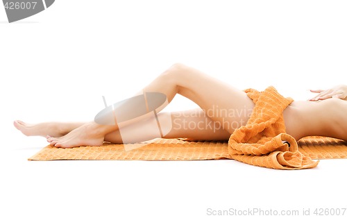 Image of long legs of relaxed lady with orange towel