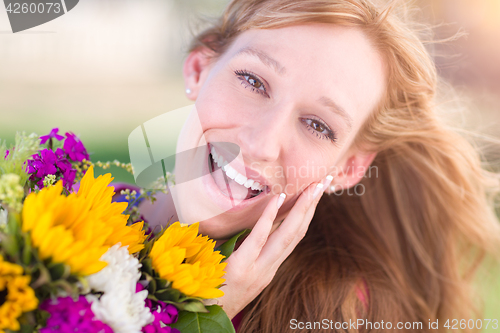 Image of Outdoor Portrait of an Excited Young Adult Brown Eyed Woman Hold