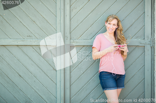 Image of Outdoor Portrait of Young Adult Brown Eyed Woman Listening To Mu