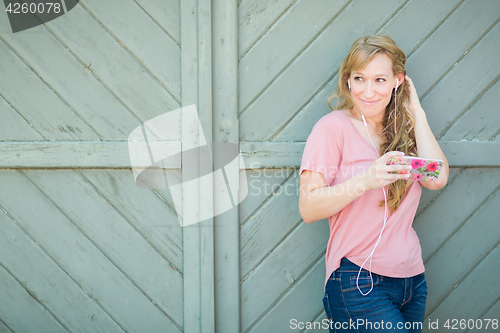 Image of Outdoor Portrait of Young Adult Brown Eyed Woman Listening To Mu