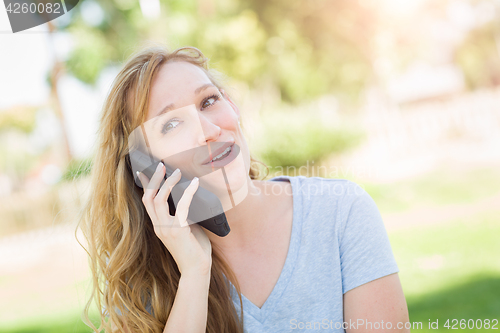 Image of Young Adult Woman Outdoors Talking on Her Smart Phone.