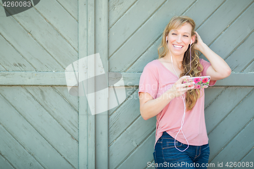 Image of Outdoor Portrait of Young Adult Brown Eyed Woman Listening To Mu
