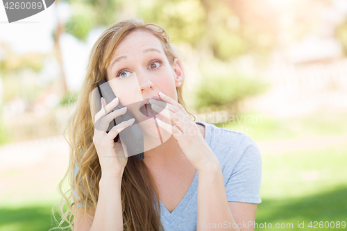 Image of Stunned Young Woman Outdoors Talking on Her Smart Phone.