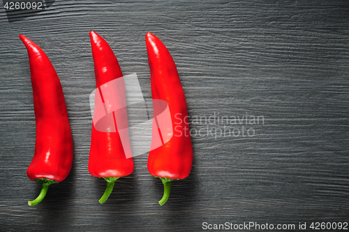 Image of Sweet red Kapia peppers on a dark shale stone background