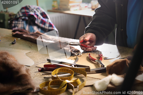 Image of A tailor, leather craft Workshop furrier, utensils, tools and pieces of natural fur