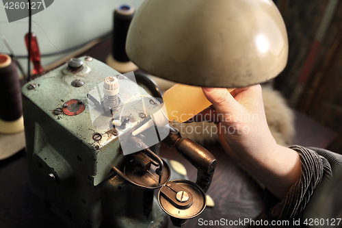 Image of Tailor lubricates the sewing machine lubricant 