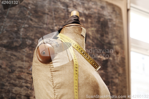 Image of A tailor, a furrier A piece of grain leather, tape measure pinned on a mannequin in studio fur