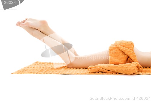 Image of long legs of relaxed lady with orange towel