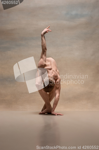 Image of The male ballet dancer posing over gray background
