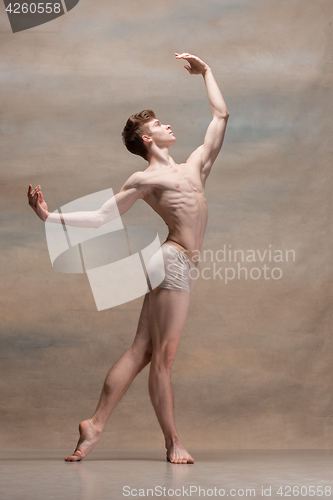 Image of The male ballet dancer posing over gray background