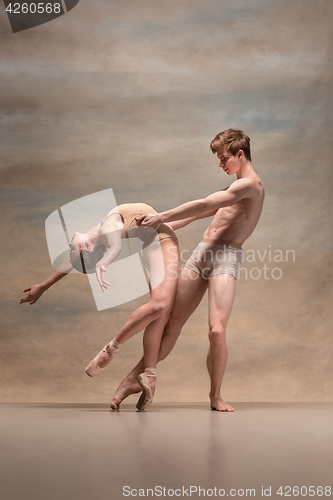 Image of Couple of ballet dancers posing over gray background