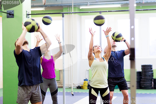 Image of group of people with medicine ball training in gym