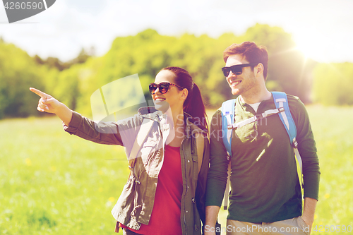 Image of happy couple with backpacks hiking outdoors