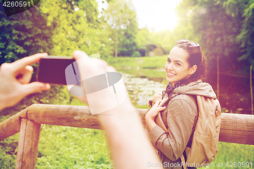 Image of couple with backpacks taking picture by smartphone