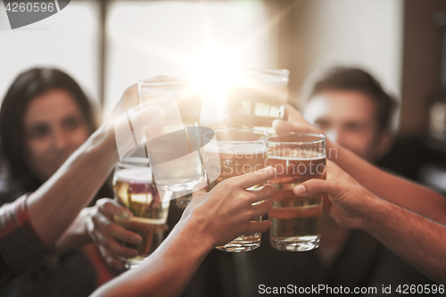 Image of happy friends drinking beer at bar or pub