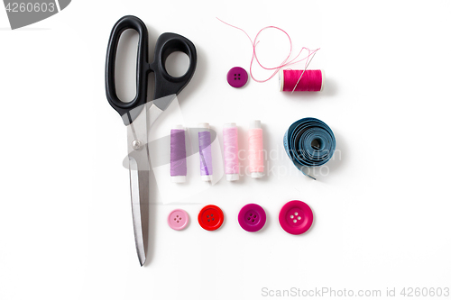 Image of scissors, sewing buttons, threads and tape measure