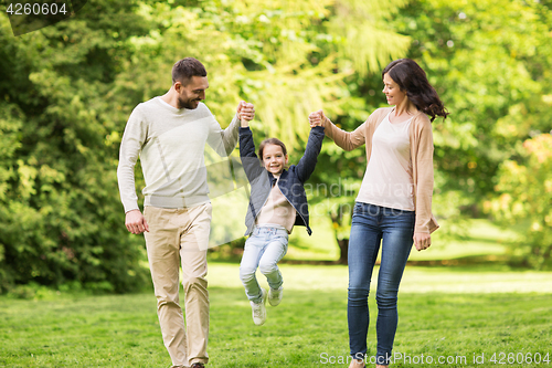 Image of happy family walking in summer park and having fun