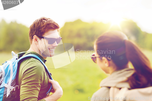 Image of smiling couple with backpacks in nature
